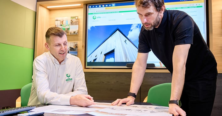 Two men who work at Elite Systems GB a modular building company, around a table discussing a modular building plan.