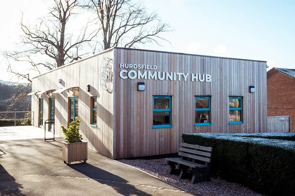 Exterior of the Hurdsfield Community Hub, a modern single-storey community building with timber cladding and accessible entrance.