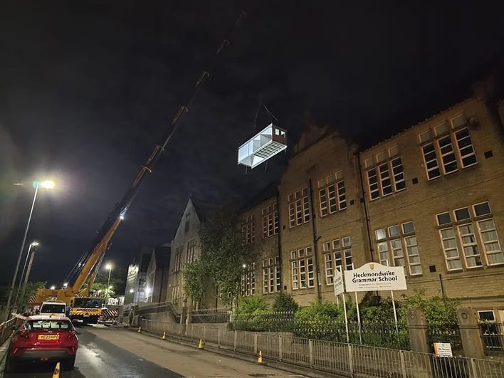Mobile crane lifting a permanent modular classroom into position at Heckmondwike Grammar School during installation