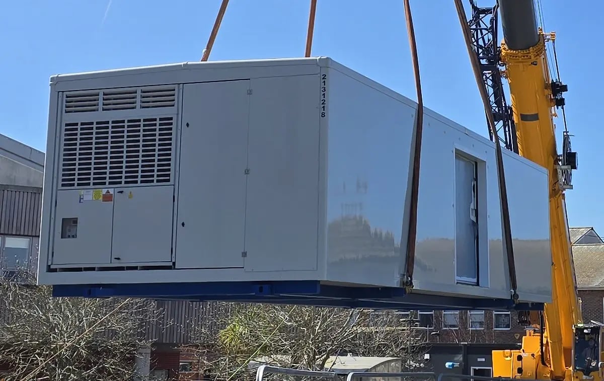 Crane lifting a prefabricated module into position during the installation of the temporary decant modular mortuary facility at St Richard's Hospital, Chichester.