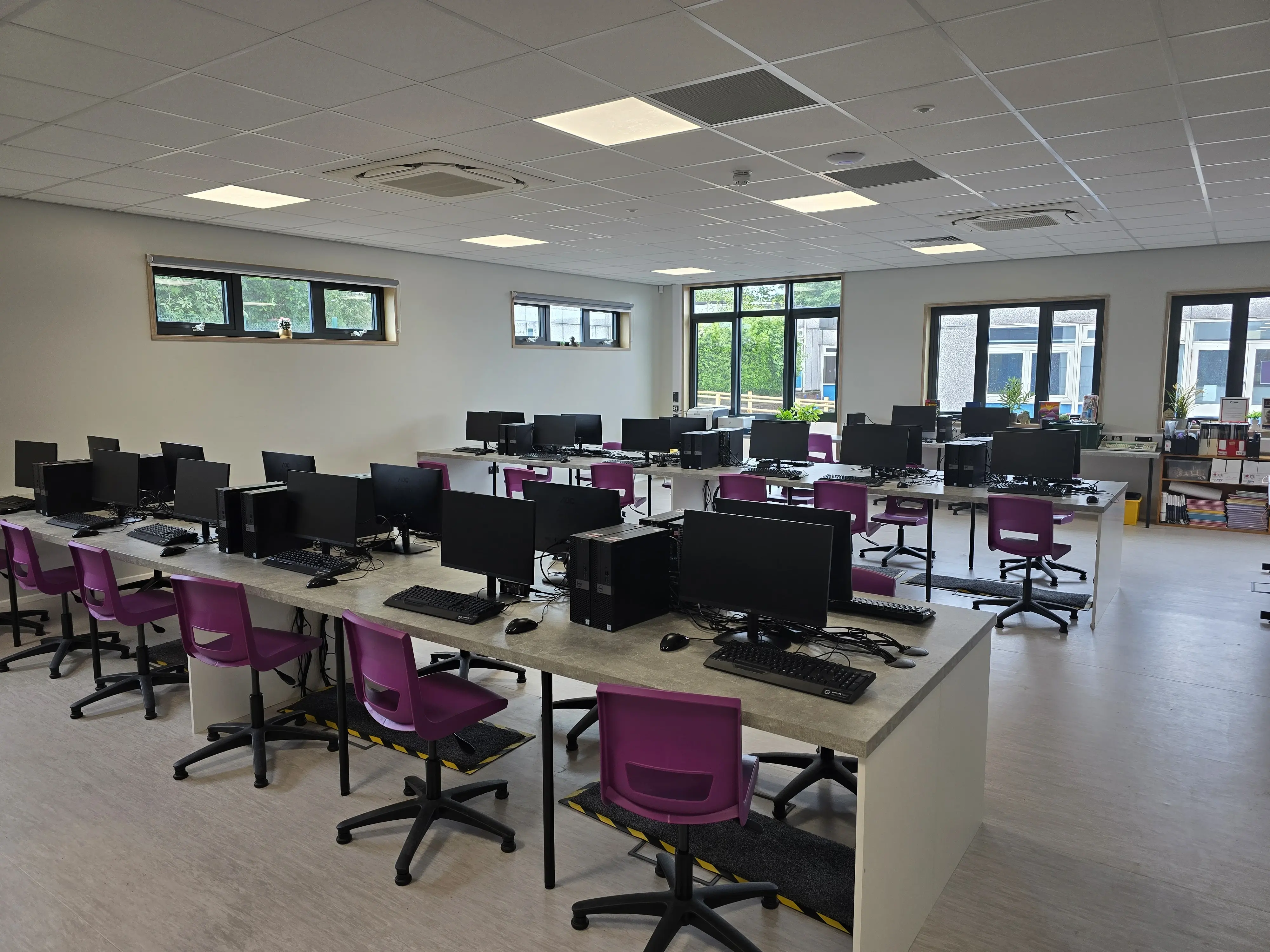 Modern sustainable modular school building with rooftop solar panels overlooking sports fields, designed for energy efficiency, renewable power generation, and environmentally friendly educational spaces.
