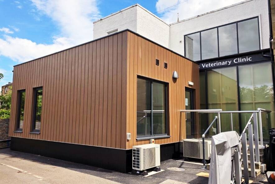 High-quality modular building hire with timber cladding and large windows beside a veterinary clinic, showcasing durable materials and seamless integration.