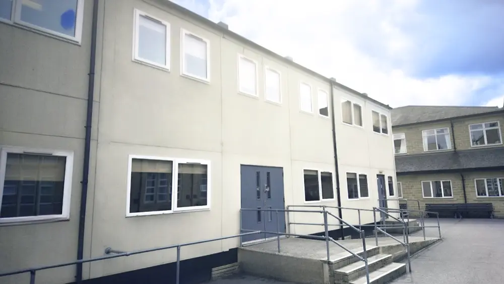 Temporary modular classrooms at Heckmondwike Grammar School, featuring a two-storey prefabricated school building with wheelchair access and exterior walkway