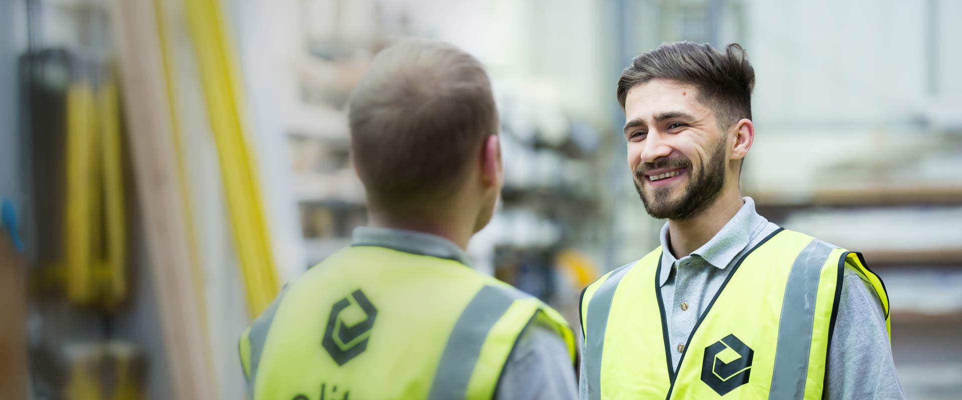 Construction professionals wearing safety vests discussing modular buildings project planning at construction site.