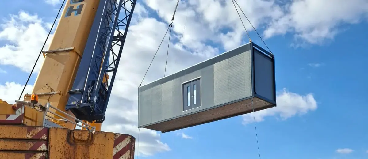 A modular mortuary building module being lifted into position by crane during installation at St Richard's Hospital as part of a temporary decant healthcare facility.