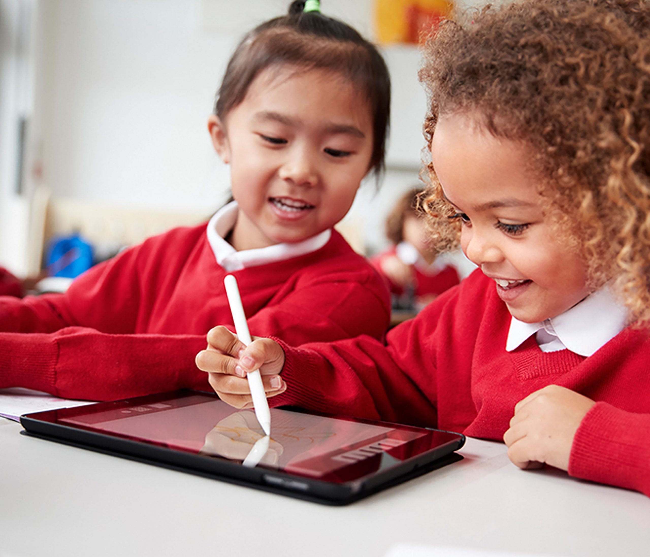 two primary school aged children using a tablet in the classroom