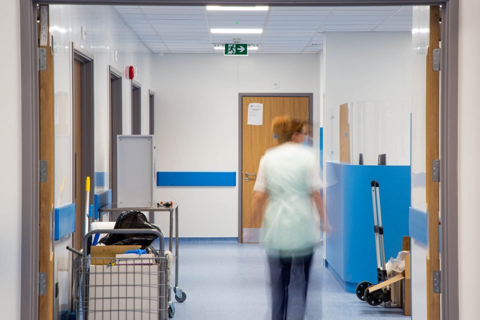 nurse walking down a hallway of a hospital