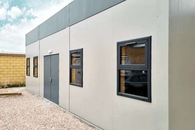Modular healthcare buildings in light grey with dark grey trimmed windows
