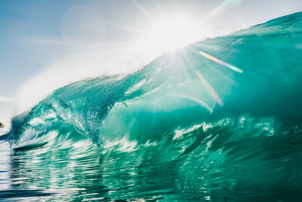 sunburst over a wave crest on the open sea.