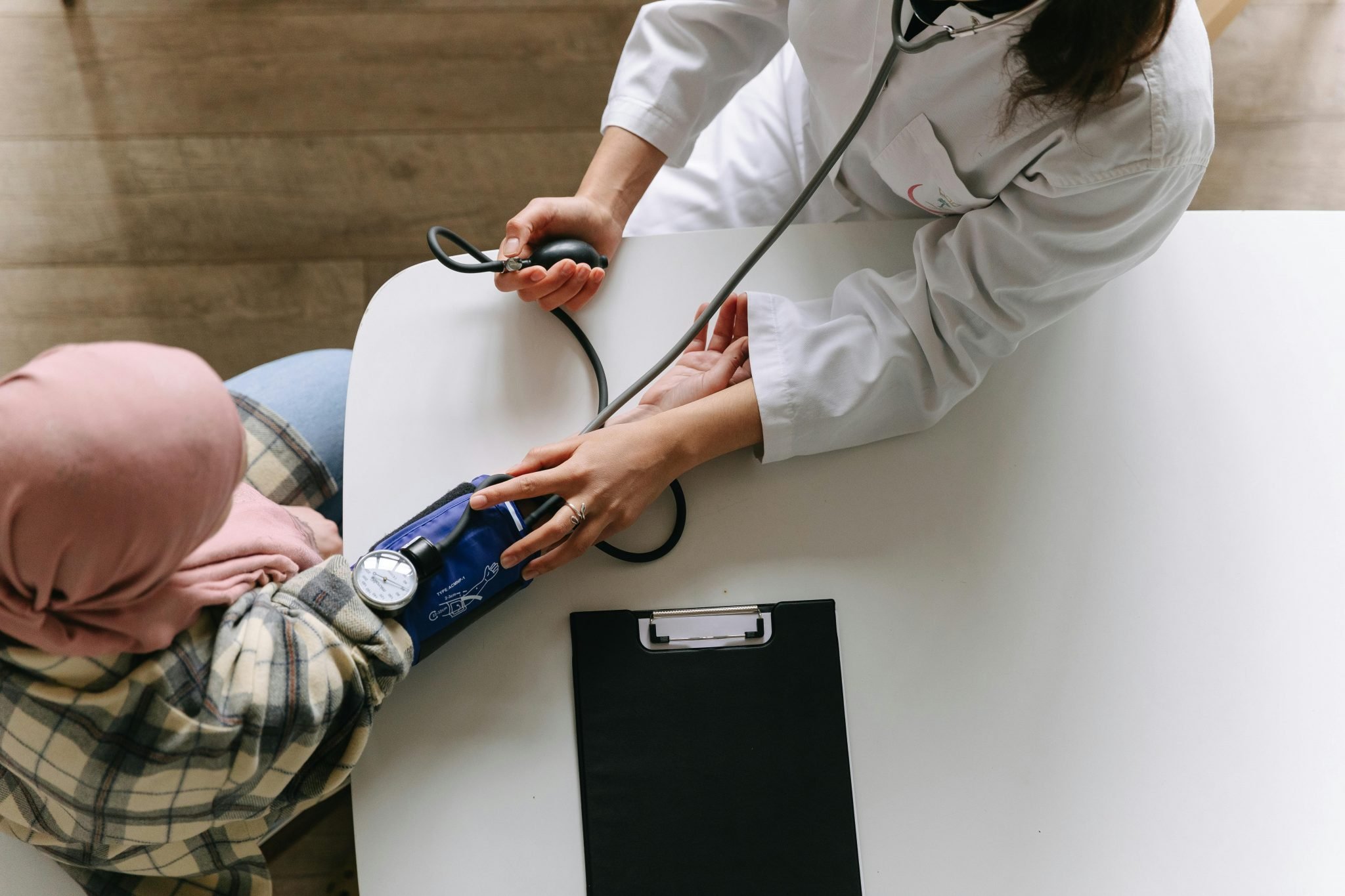 medical professional using blood pressure machine on patient from above